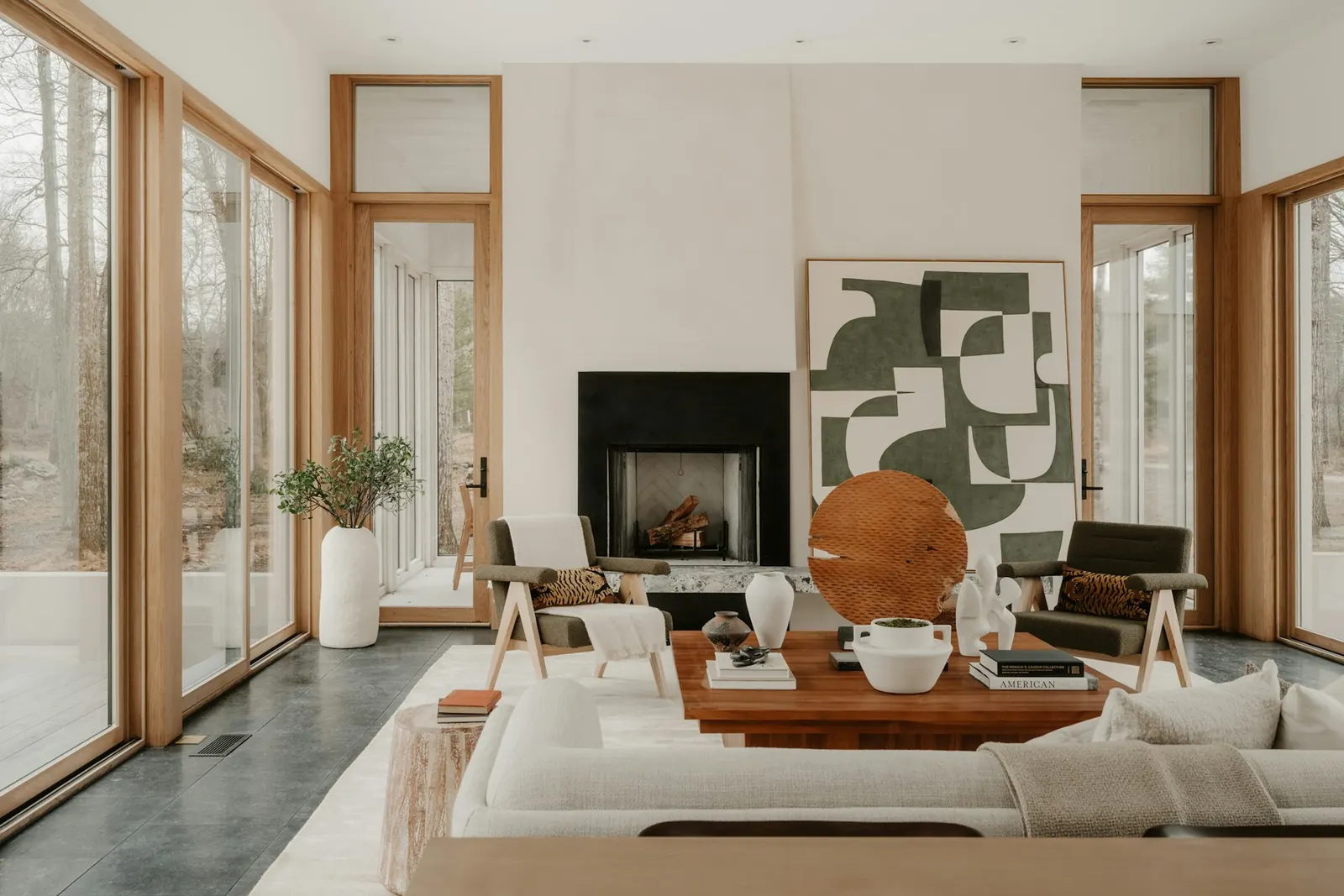 A finished living room with a see-through fireplace, abstract canvas and lounge chairs, Thornhill